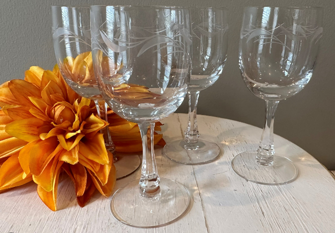 wine glasses on a table and an orange flower
