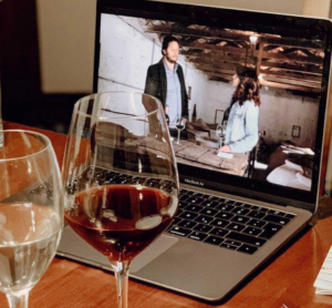 a laptop and two glasses of wine showing virtual wine tasting