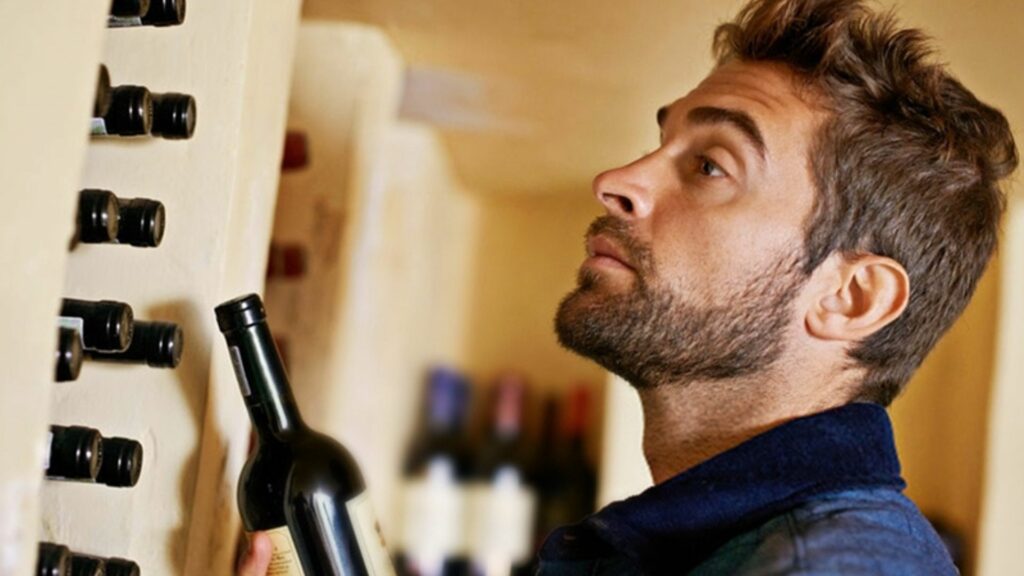 a man holding a wine bottle showing wine storage standards