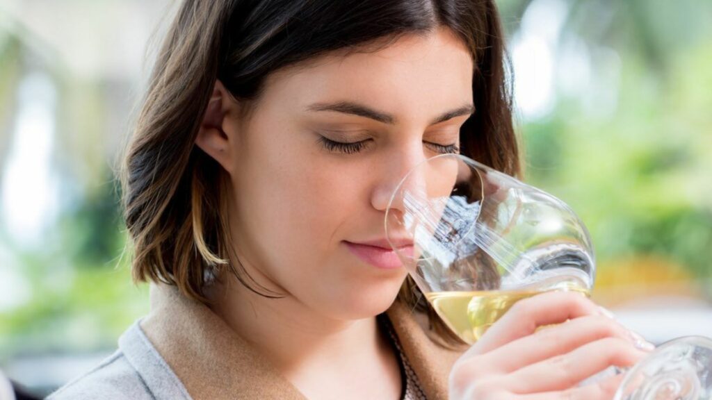 a lady smelling wine showing Wine Tasting at Home